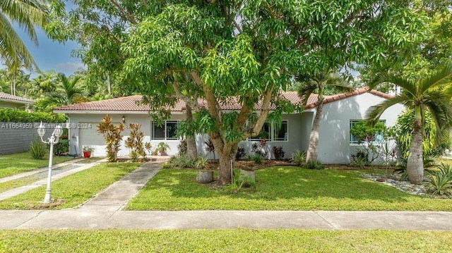 mediterranean / spanish house with a front yard and a garage