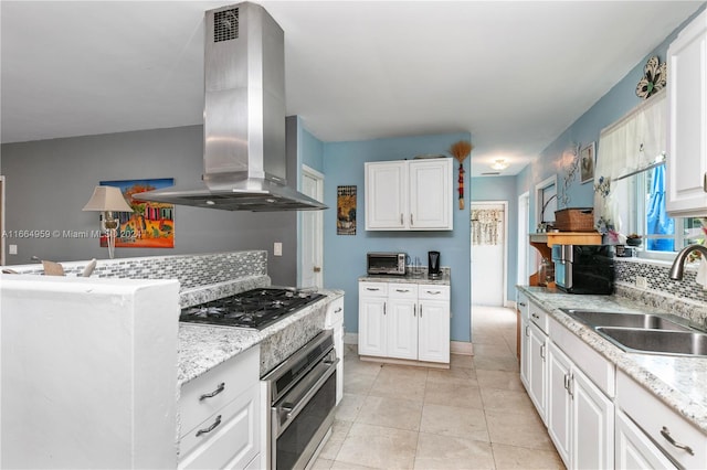 kitchen with wall chimney exhaust hood, white cabinetry, stainless steel oven, and black gas stovetop