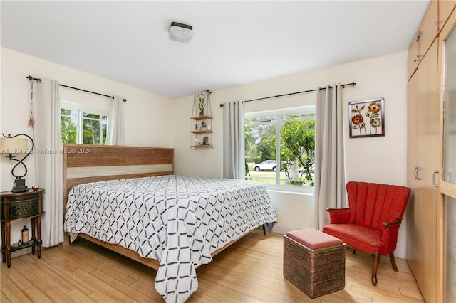 bedroom with multiple windows and hardwood / wood-style flooring