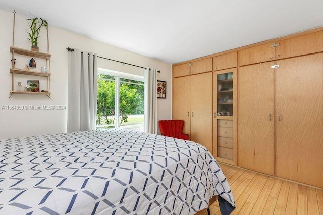 bedroom with access to outside, light hardwood / wood-style flooring, and a closet