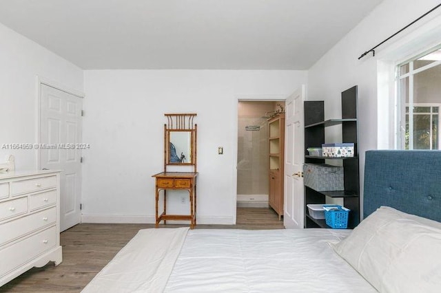 bedroom featuring connected bathroom and hardwood / wood-style flooring