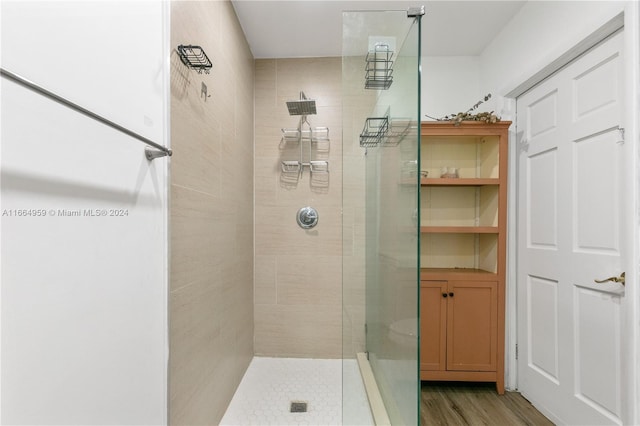 bathroom featuring hardwood / wood-style floors and tiled shower