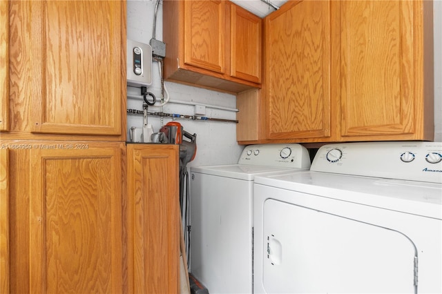 laundry area featuring cabinets and washing machine and clothes dryer