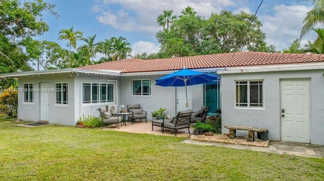 back of house with a patio, an outdoor living space, and a yard