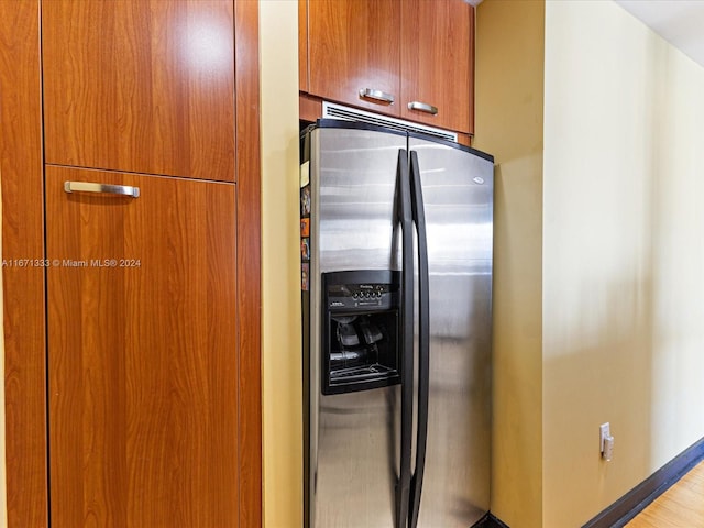 kitchen with stainless steel fridge with ice dispenser and light hardwood / wood-style flooring