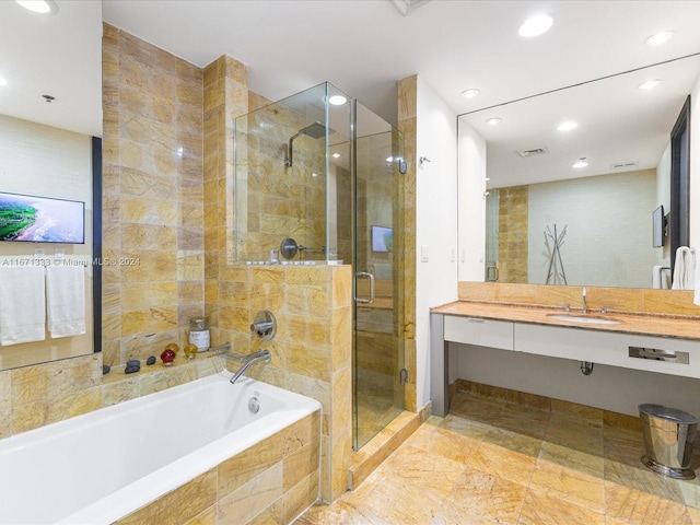 bathroom with vanity and shower with separate bathtub