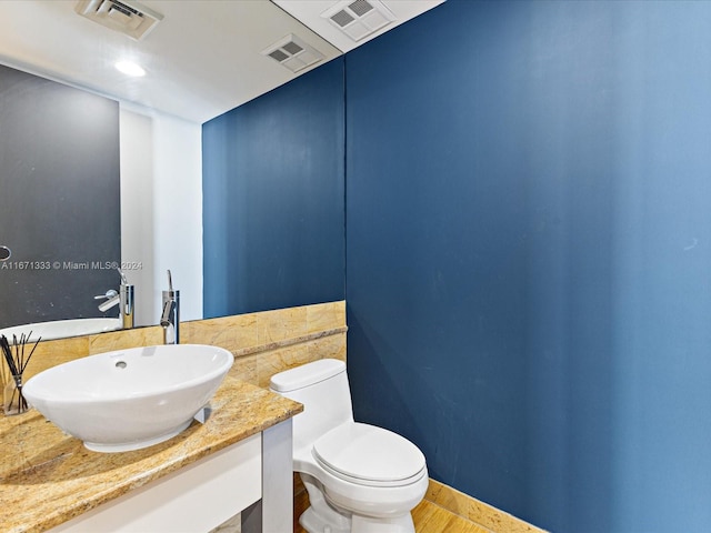 bathroom featuring vanity, toilet, and wood-type flooring