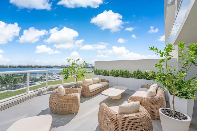 view of patio featuring a water view, an outdoor living space, and a balcony