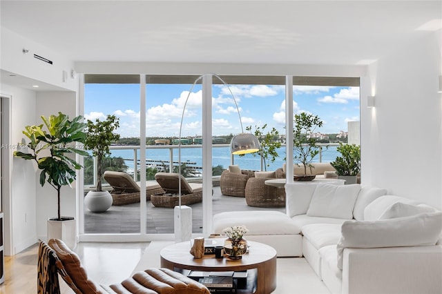 living room with light hardwood / wood-style floors and a water view