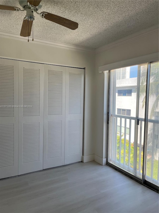 unfurnished bedroom with multiple windows, light hardwood / wood-style floors, ceiling fan, and a closet