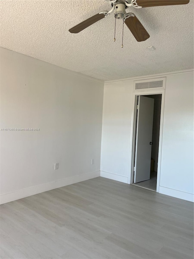 unfurnished room with light hardwood / wood-style floors, a textured ceiling, and ceiling fan