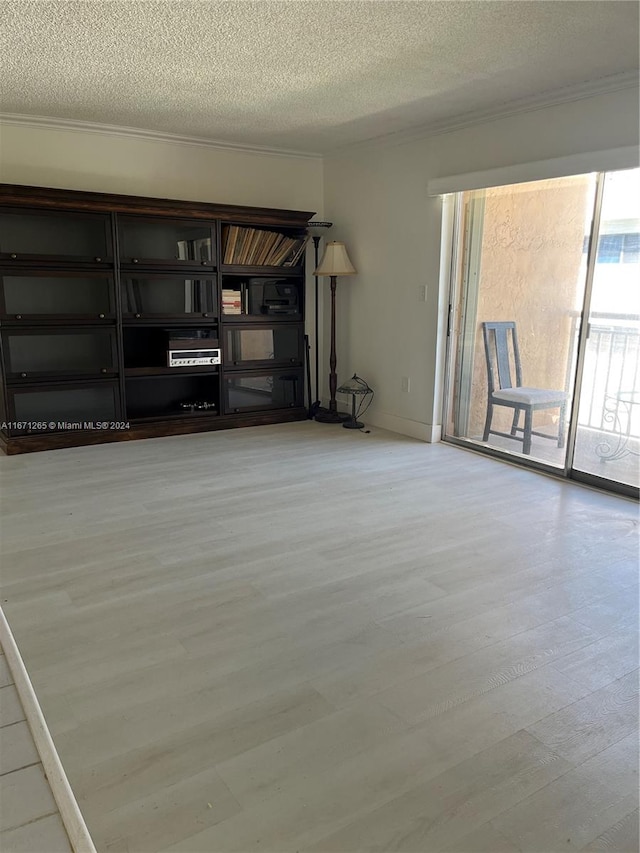 unfurnished living room with a textured ceiling and light hardwood / wood-style flooring