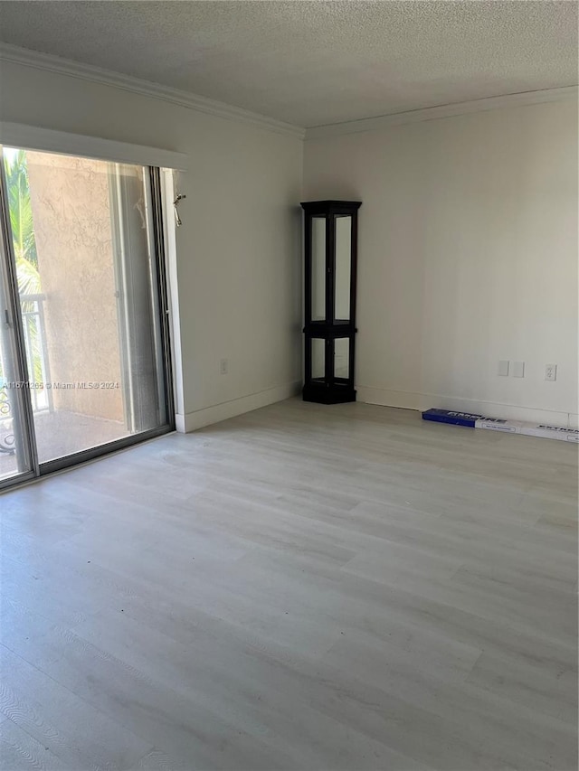 unfurnished room with light hardwood / wood-style floors, crown molding, and a textured ceiling