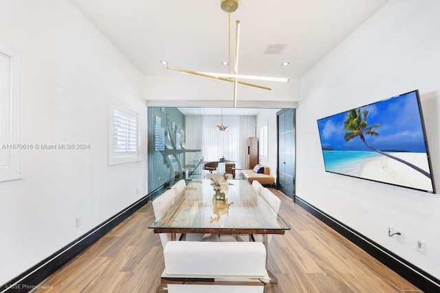 dining space featuring hardwood / wood-style floors and a chandelier