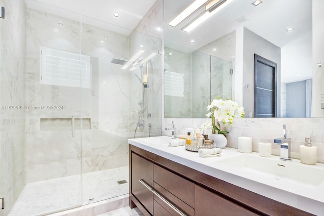 bathroom featuring backsplash, vanity, tile walls, and walk in shower