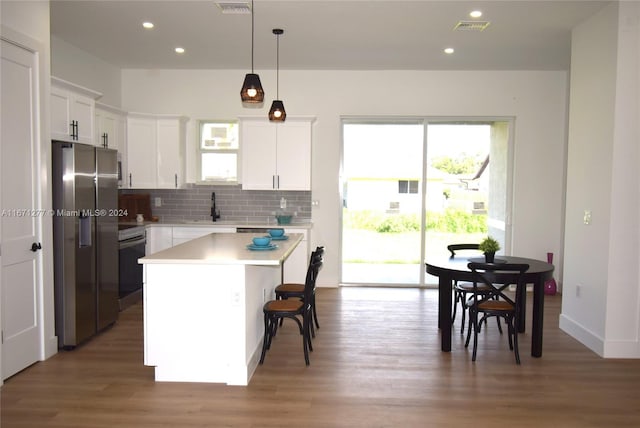 kitchen featuring plenty of natural light, a center island, white cabinetry, and appliances with stainless steel finishes