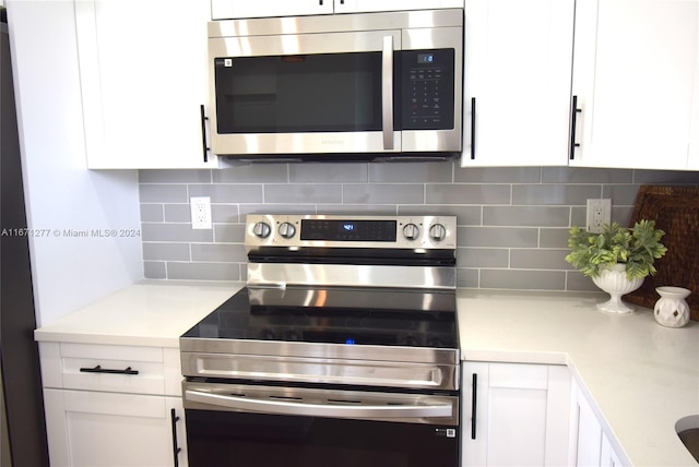 kitchen featuring white cabinets, appliances with stainless steel finishes, and tasteful backsplash