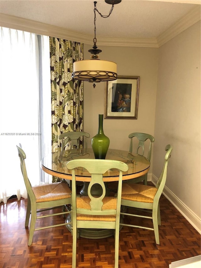 dining space with dark parquet floors and crown molding