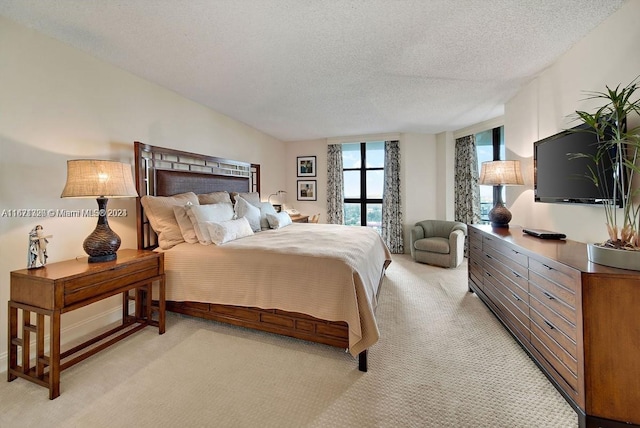 bedroom featuring a textured ceiling and light colored carpet