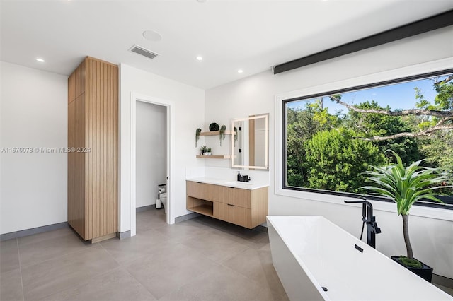 bathroom featuring vanity, toilet, and a bath