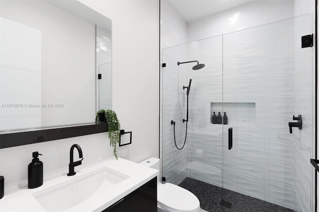 bathroom with vanity, toilet, and a shower with shower door