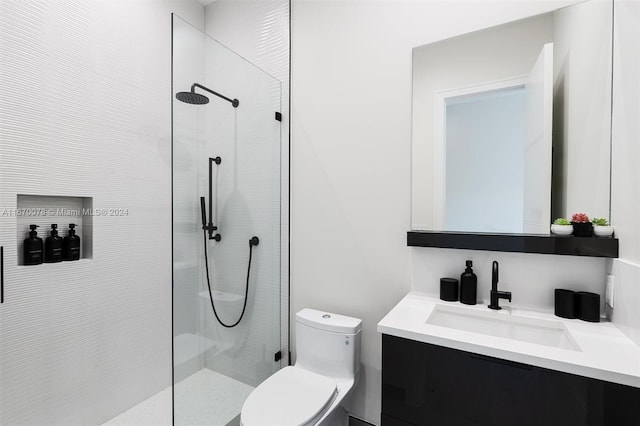 bathroom featuring a tile shower, vanity, and toilet