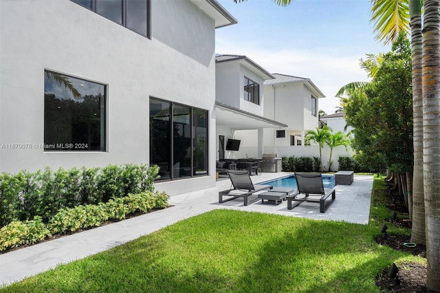 rear view of property featuring a yard and a patio area