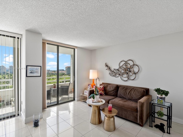 living room featuring floor to ceiling windows, a textured ceiling, and light tile patterned floors