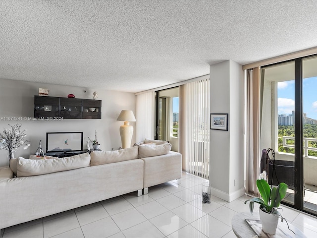 living room featuring light tile patterned flooring, a wall of windows, and a textured ceiling