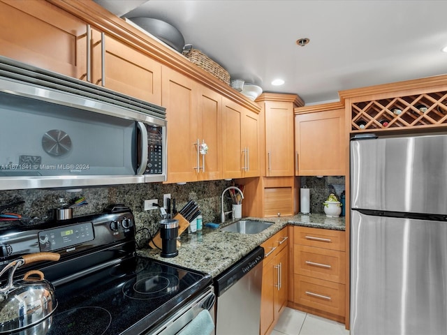 kitchen featuring backsplash, stone counters, sink, and stainless steel appliances