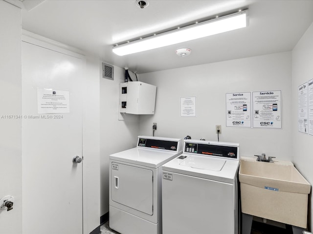 clothes washing area with washer and dryer and sink