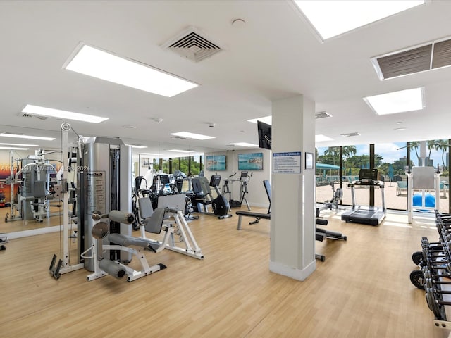 gym with light hardwood / wood-style flooring and floor to ceiling windows