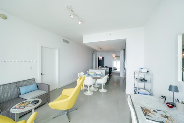 living room featuring concrete flooring and rail lighting