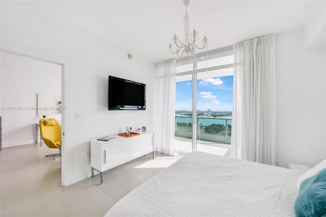 bedroom featuring concrete flooring, an inviting chandelier, and access to exterior