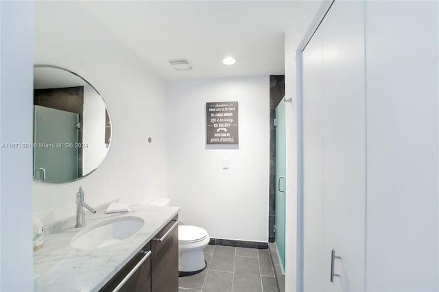 bathroom with walk in shower, vanity, toilet, and tile patterned floors