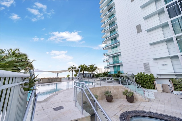 view of pool with a water view and a patio area