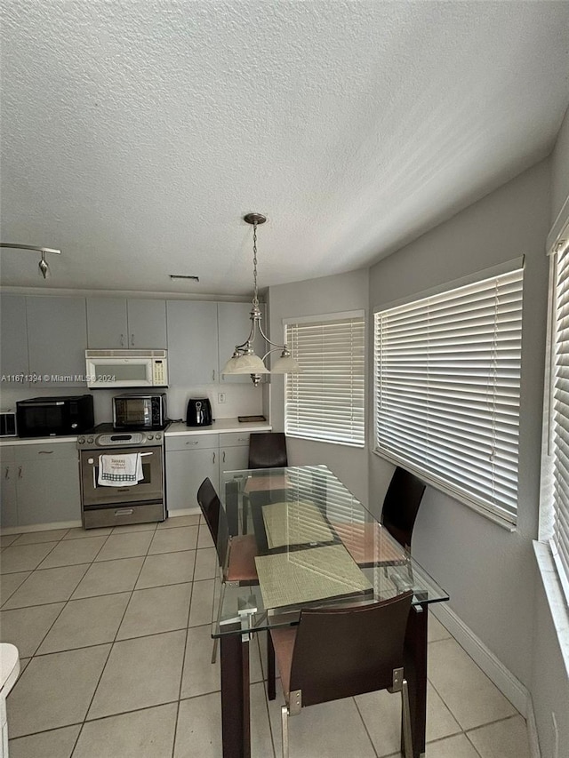 tiled dining area featuring a textured ceiling