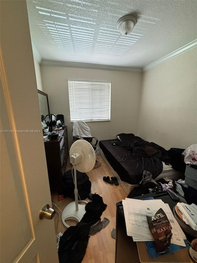 bedroom with ornamental molding and hardwood / wood-style floors