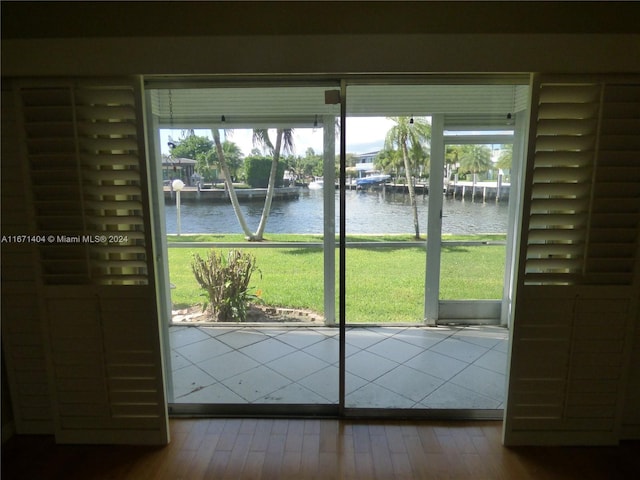 doorway to outside with a water view and hardwood / wood-style floors