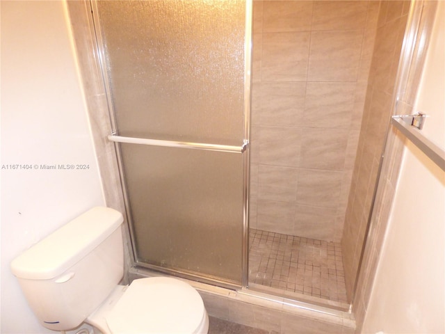 bathroom with toilet and an enclosed shower