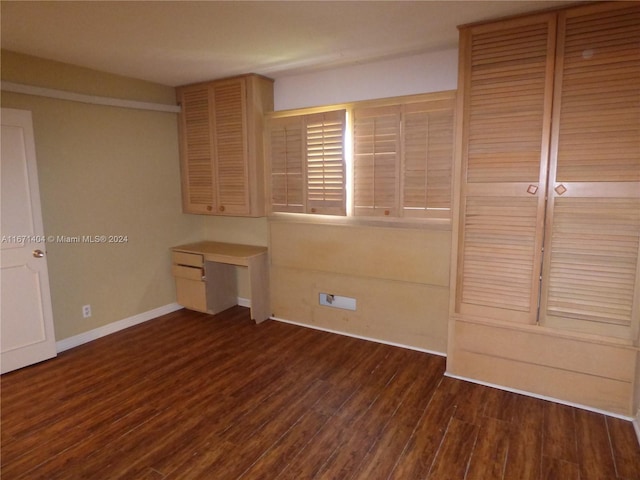 unfurnished bedroom featuring dark hardwood / wood-style flooring and a closet