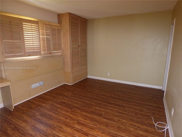 spare room with dark wood-type flooring