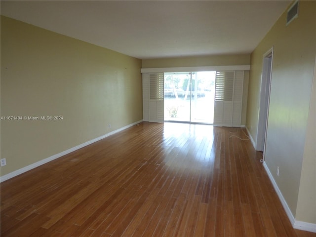 empty room with hardwood / wood-style floors