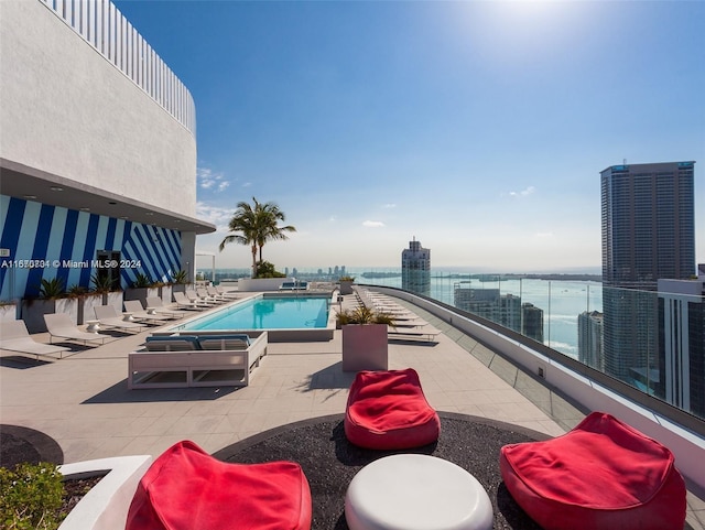 view of swimming pool featuring a water view and a patio area