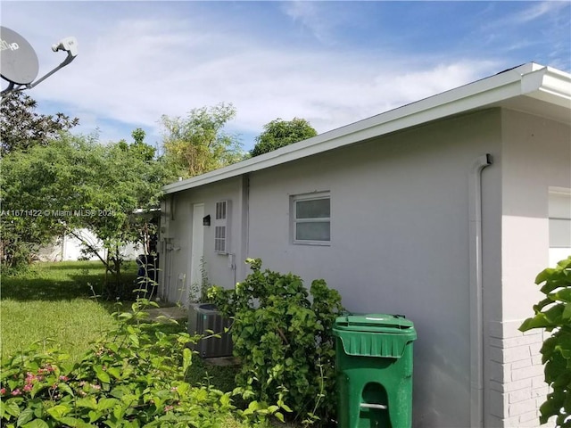 view of property exterior with a yard and central AC unit