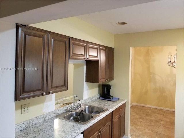 kitchen featuring light stone counters, light tile patterned floors, and sink