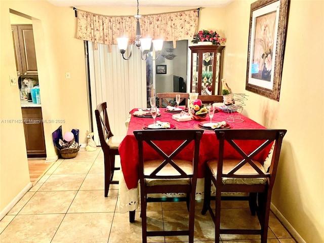 dining space featuring light tile patterned floors and a chandelier