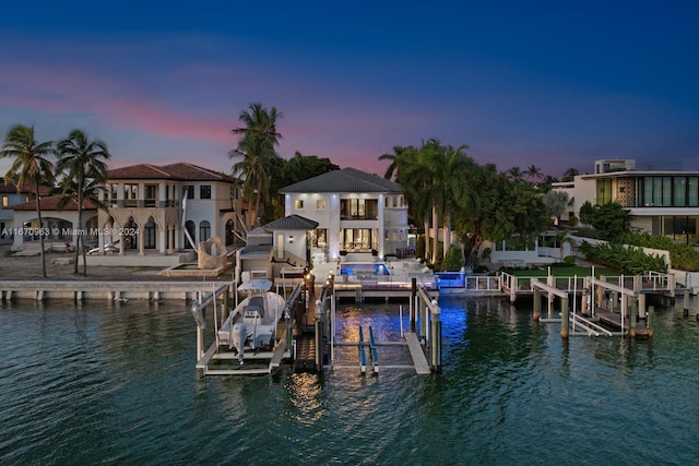 dock area with a water view, a balcony, and boat lift