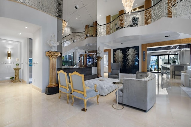 tiled living room with baseboards, a notable chandelier, and a high ceiling