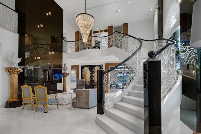 stairs featuring a chandelier and a towering ceiling